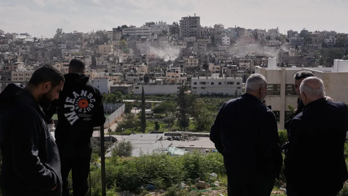 Palestinians watch as Israeli bulldozers claw down their West Bank homes
